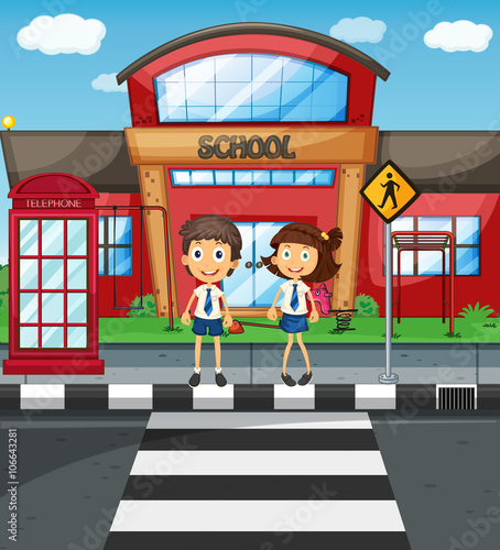 Two students crossing road in front of school