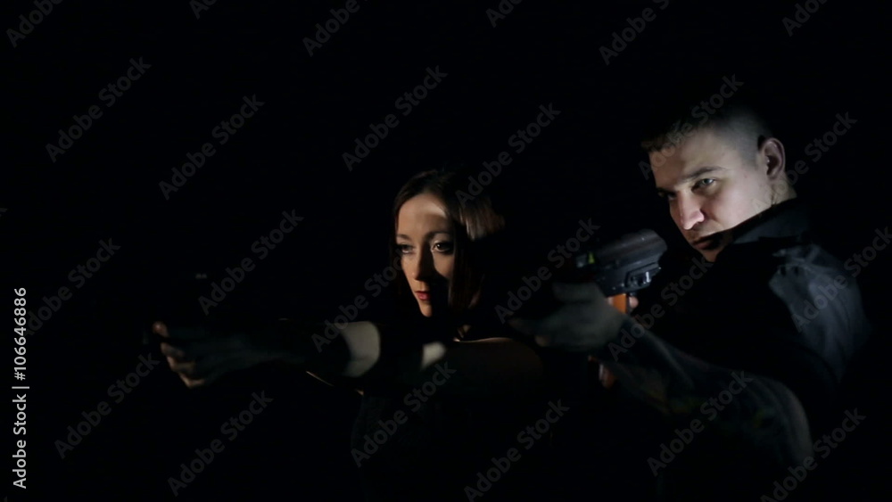 Firearms practice: Woman and man shooting laser weapon Firearms practice: Woman and man shooting laser weapon