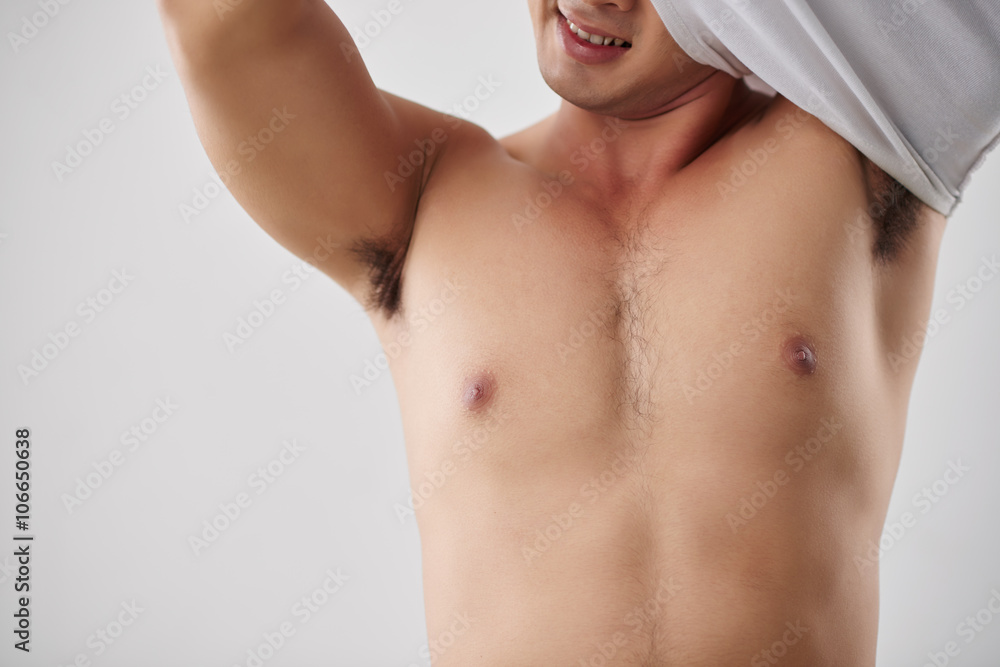 Cropped image of smiling man taking off shirt