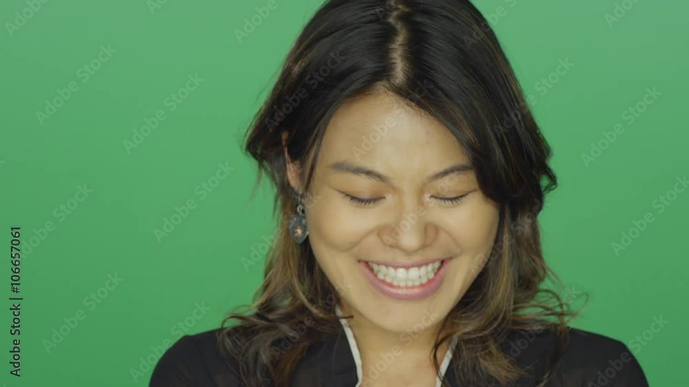 Young Asian woman smiling and laughing, on a green screen studio background Young Asian woman smiling and laughing, on a green screen studio background