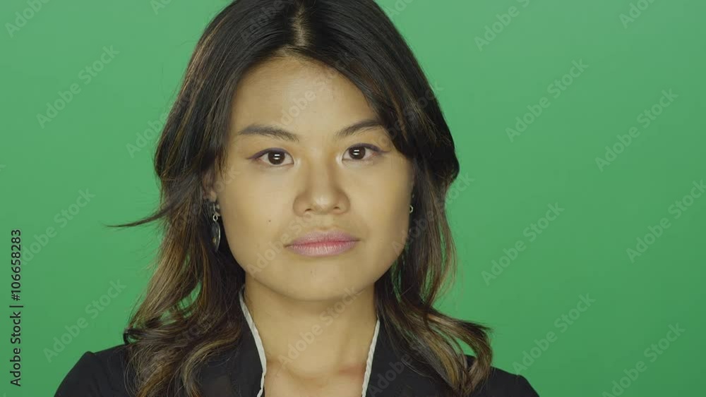 Young Asian woman crossing her arms and looking upset, on a green screen studio background Young Asian woman crossing her arms and looking upset, on a green screen studio background
