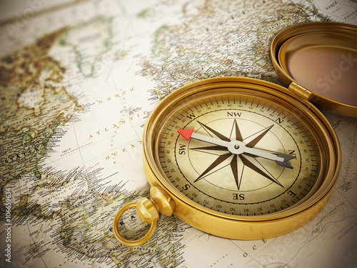 Vintage compass standing on old map