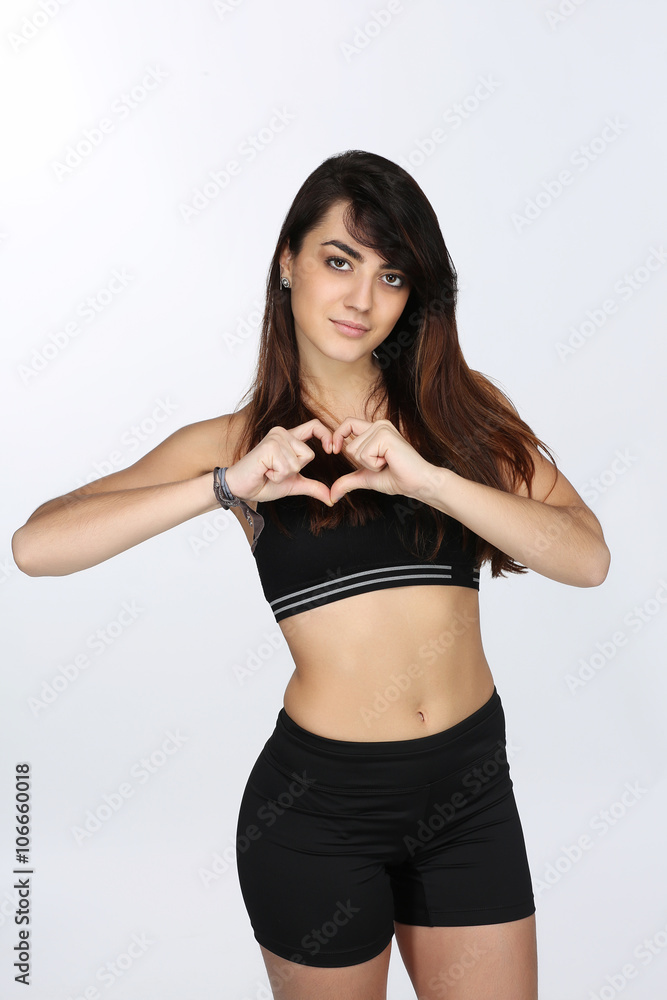 Fototapeta premium Portrait d'une jeune femme qui fait un coeur avec ces doigts
