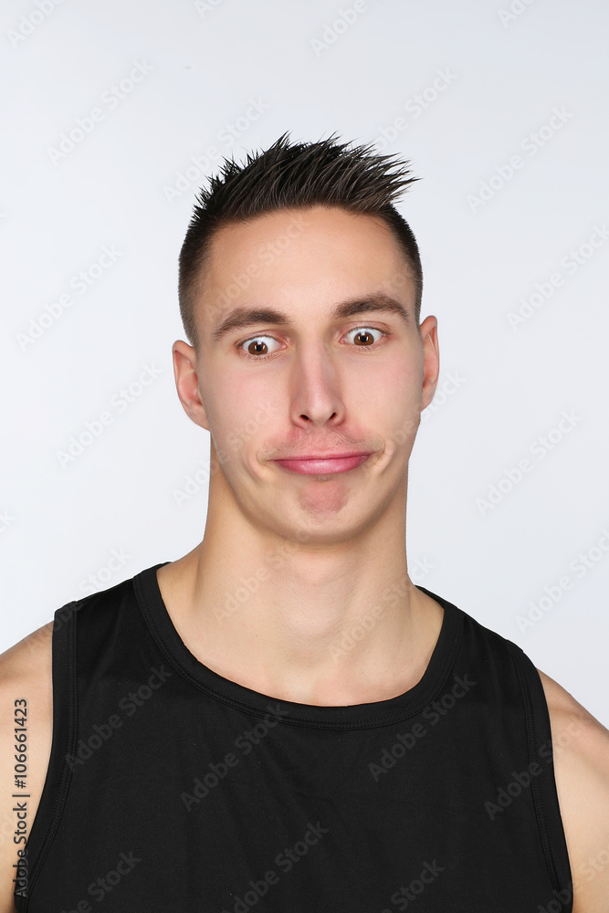 Portrait d'un jeune homme sur fond blanc qui fait des grimaces Portrait d'un jeune homme sur fond blanc qui fait des grimaces