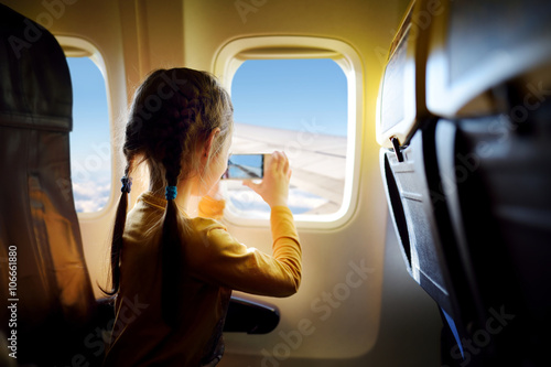 Adorable little girl traveling by an airplane