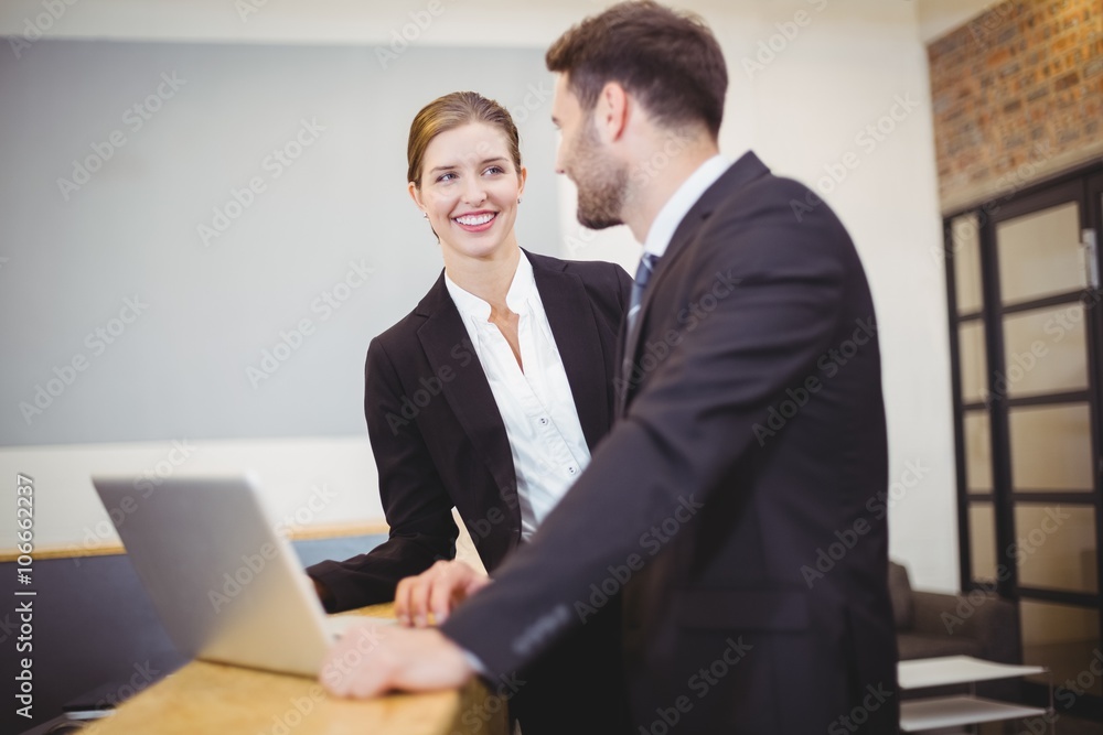 Business people talking while standing by counter Business people talking while standing by counter
