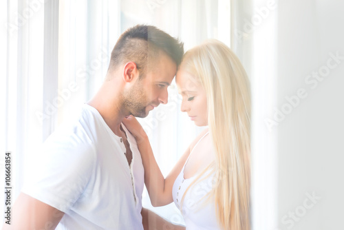 Beautiful young couple standing at the window 