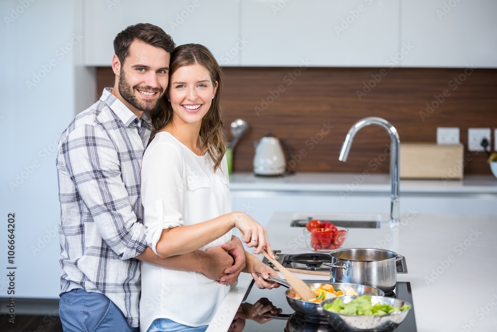 Man embracing woman while preparing food Man embracing woman while preparing food