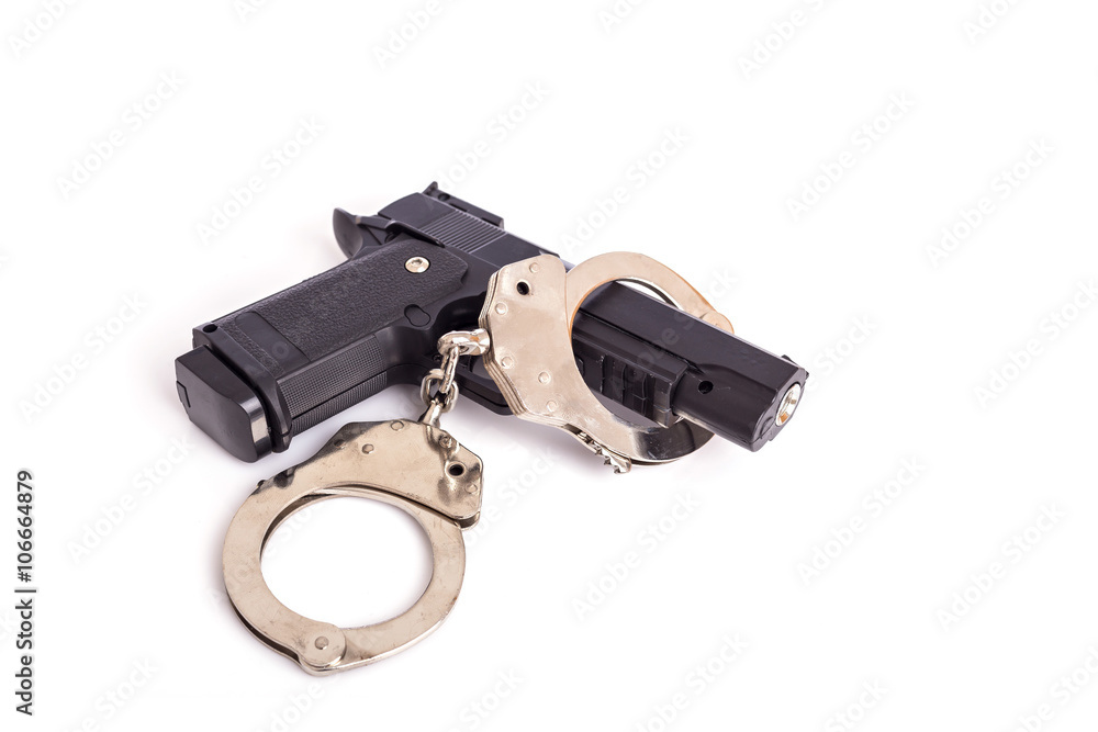 Close up gun and handcuffs isolated on white Close up gun and handcuffs isolated on white
