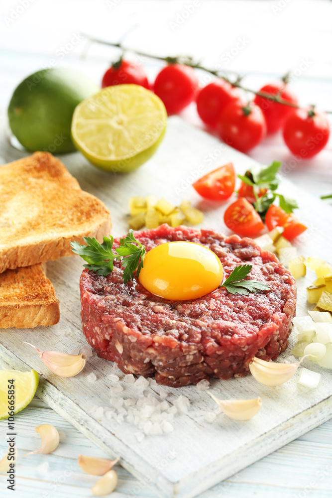 Beef tartare with egg yolk on a blue wooden table Beef tartare with egg yolk on a blue wooden table