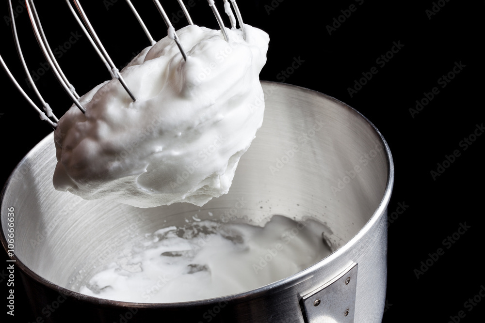 Φωτογραφία Beaten egg’s white in metal stainless steel mixing bowl with whisker and remains