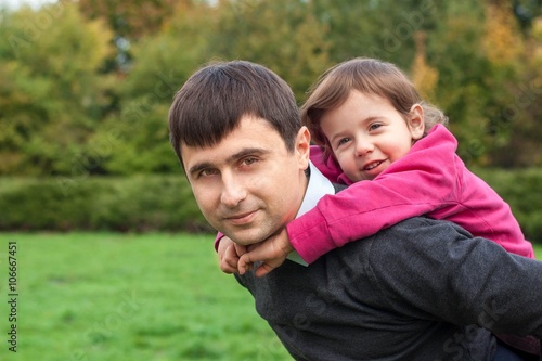 Wall Mural Daughter sitting at daddy on the back and smiling