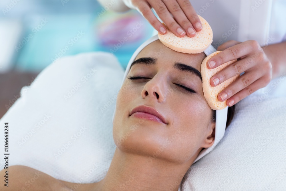 Masseuse cleaning woman face with cotton swabs Masseuse cleaning woman face with cotton swabs