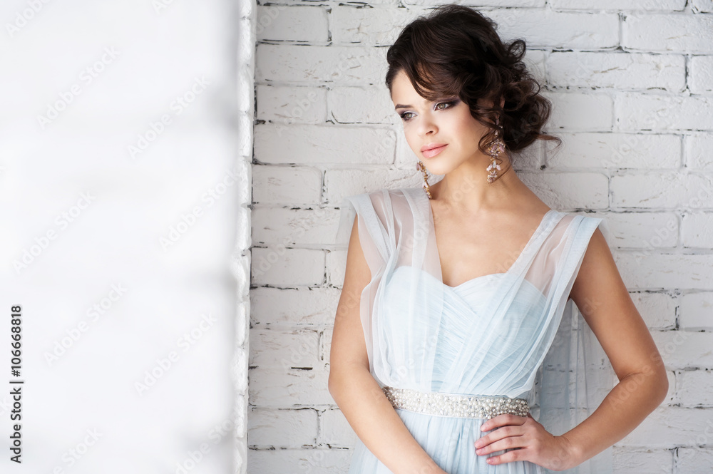 Obraz premium Portrait of a beautiful girl near white wall