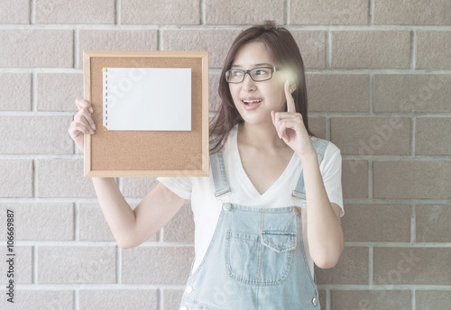 Asian woman with cork board in hand with have an idea face