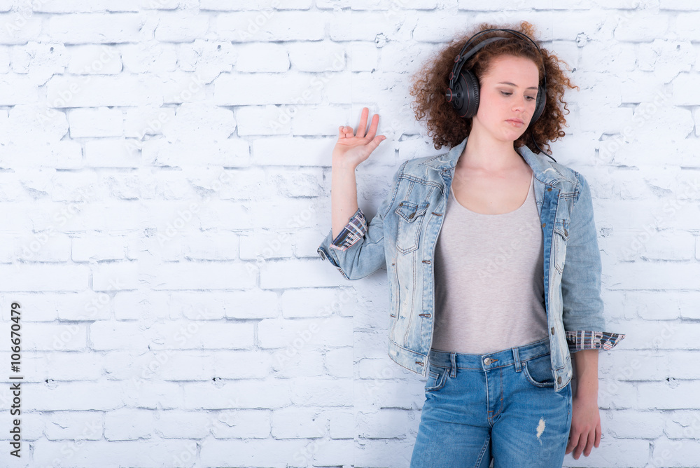 entspannte junge frau vor einer mauer entspannte junge frau vor einer mauer