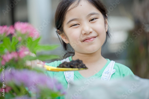 Little Asian child planting flower