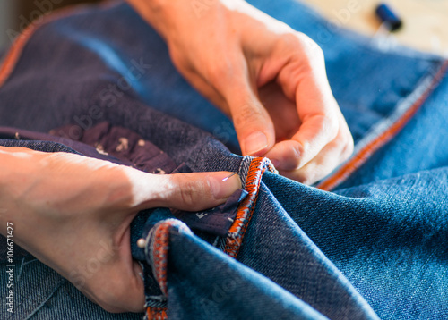 woman sewing denim. close-up on tools