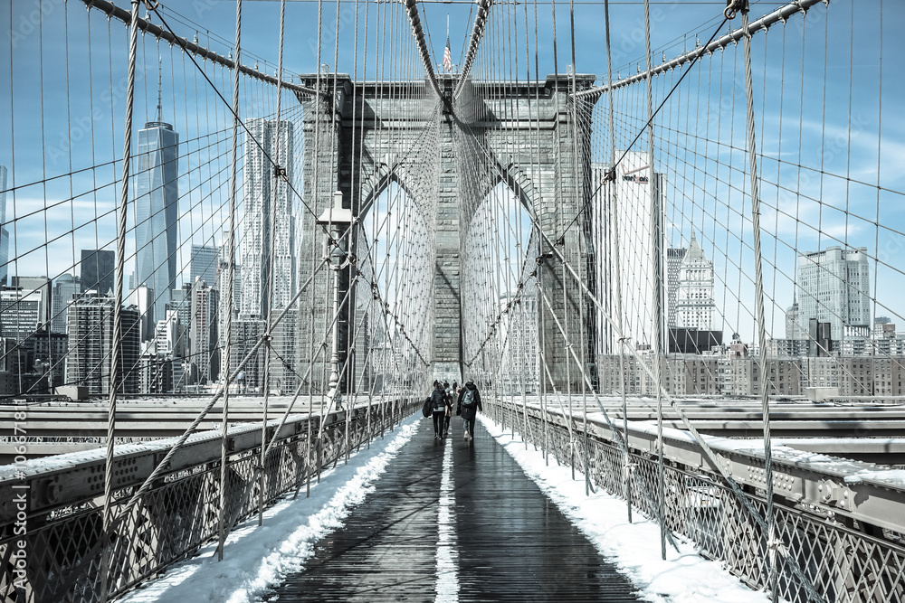 Obraz premium Winter in New York / Pedestrians cross snow-covered Brooklyn Bridge in February 2015