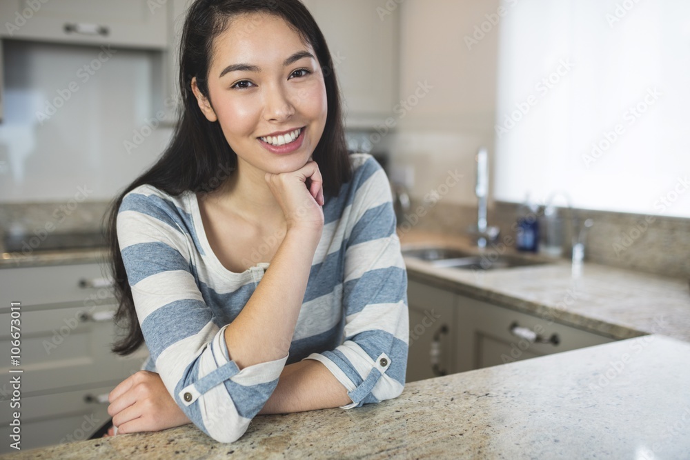 Portrait of happy woman sitting in kitchen Portrait of happy woman sitting in kitchen
