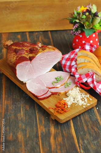 Delicious smoked ham on a wooden board with spices