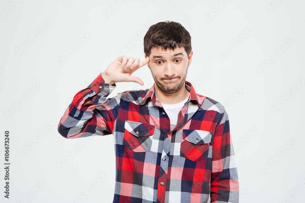 Man gesturing with his finger against temple Man gesturing with his finger against temple