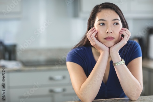Принти на полотні Young woman daydreaming in kitchen