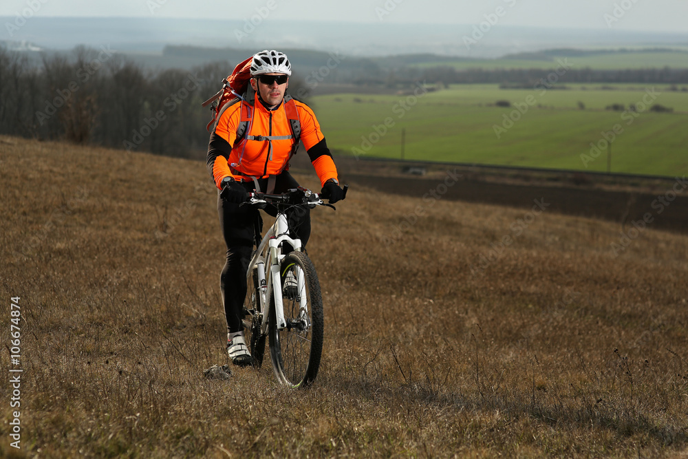 Naklejka premium Man cyclist with backpack riding the bicycle