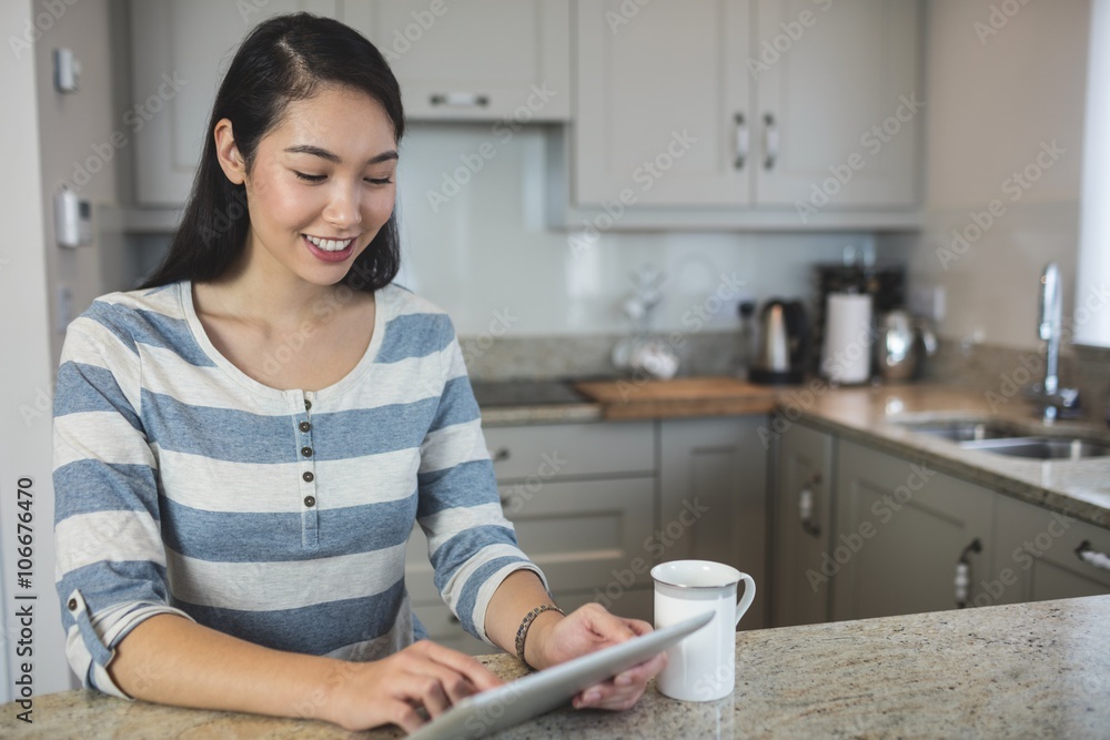 Portrait of young woman using a digital tablet in kitchen Portrait of young woman using a digital tablet in kitchen
