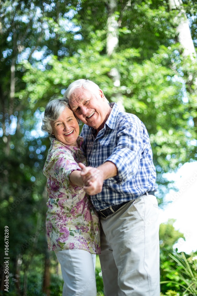 Portrait of senior couple dancing against trees Portrait of senior couple dancing against trees