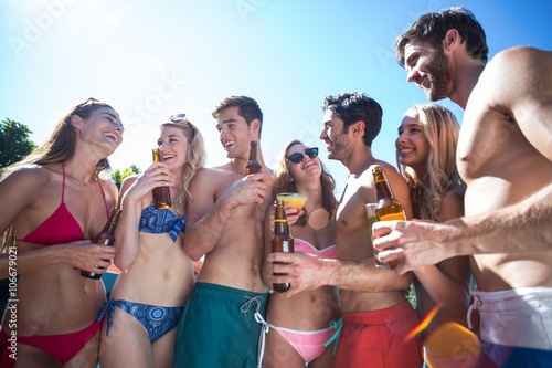 Group of happy friend holding beer bottles and glass of cocktail