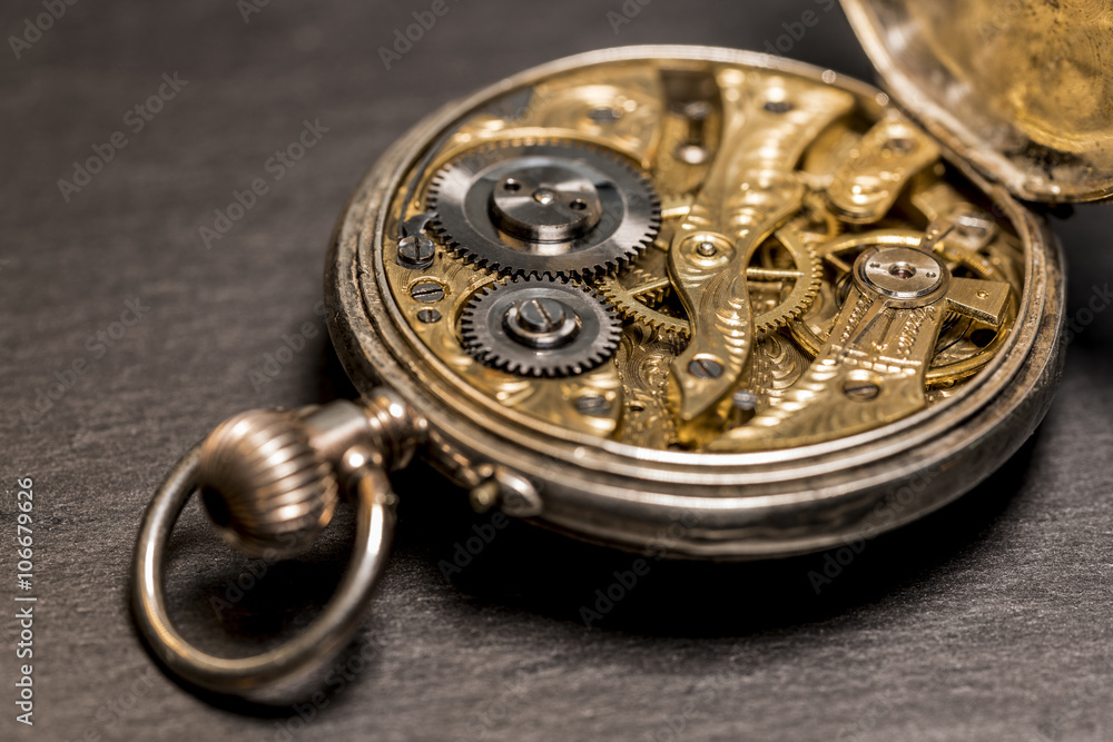 Uhrwerk einer Taschenuhr aus dem 19. Jahrhundert mit künstlerischer Unschärfe und schwarzem Grund