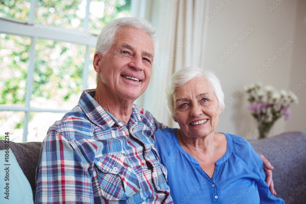 Senior couple sitting with arms around on sofa Senior couple sitting with arms around on sofa