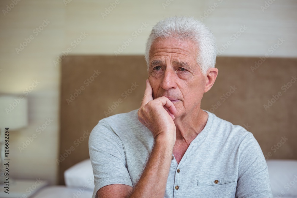 Thoughtful senior man sitting on bed Thoughtful senior man sitting on bed