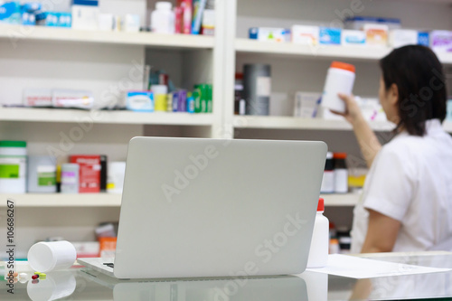 Pharmacist with laptop computer and medication in the pharmacy