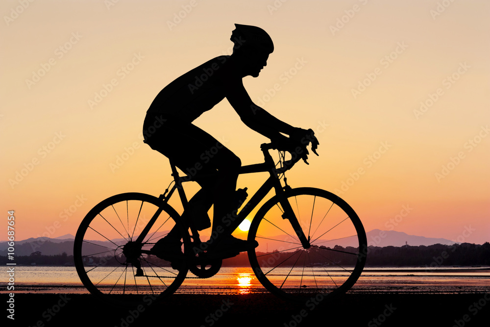 Obraz premium Man silhouette cycling at beach