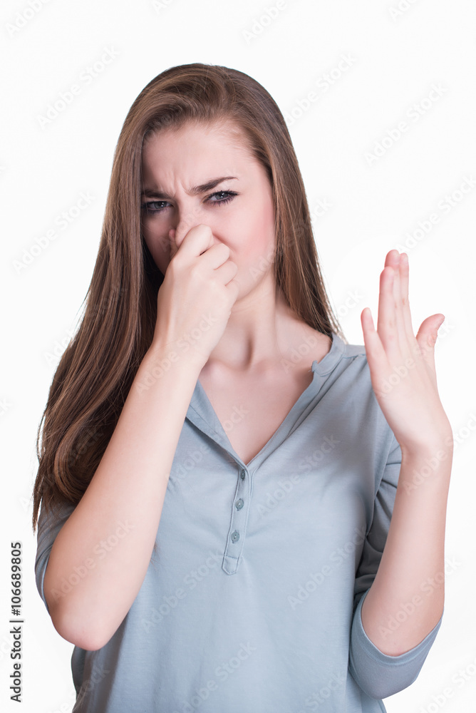 Young woman closes her nose because of the smell Young woman closes her nose because of the smell