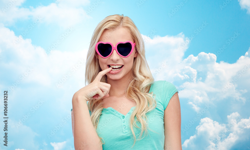 happy young woman in heart shape sunglasses