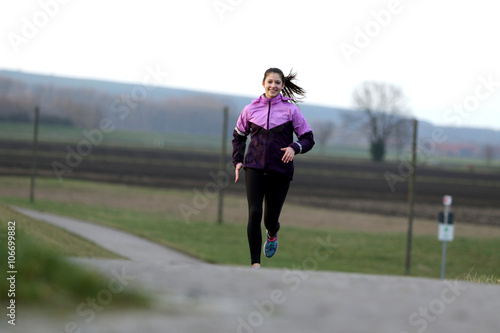 Young female runner on road