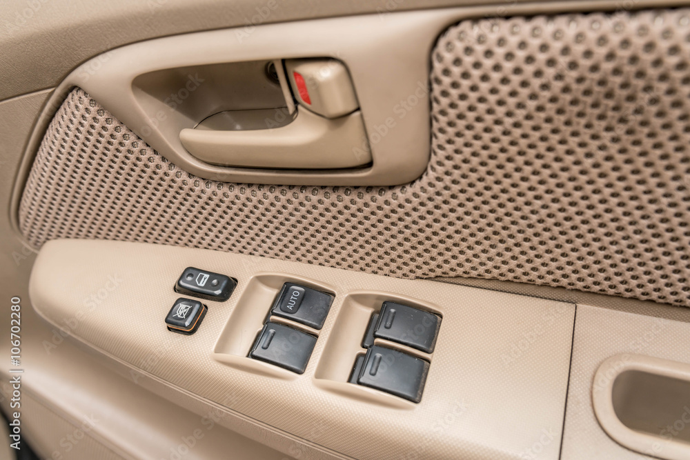 Car interior details ; door handle with windows controls - close up