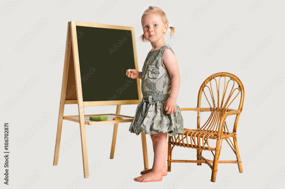 Fototapeta premium Cute girl with school black goard and marker at studio portrait with plain white background