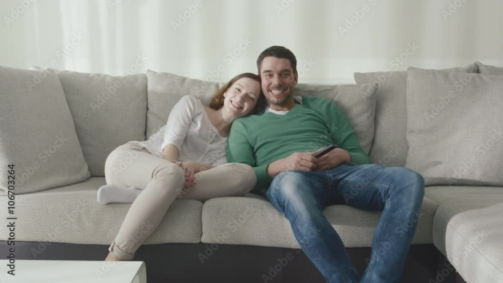 Couple is sitting on the couch at home and watching tv. Shot on RED Cinema Camera. Couple is sitting on the couch at home and watching tv. Shot on RED Cinema Camera.