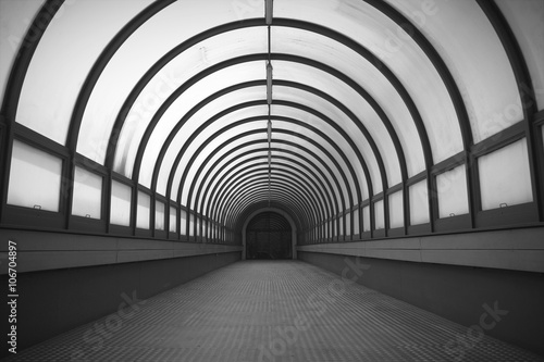 Semicircular long corridor. Illuminated way. Black and white. photo