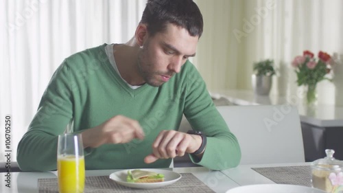 Wallpaper Mural Man is checking his smartwatch while having a lunch and orange juice in the morning. Shot on RED Cinema Camera. Torontodigital.ca