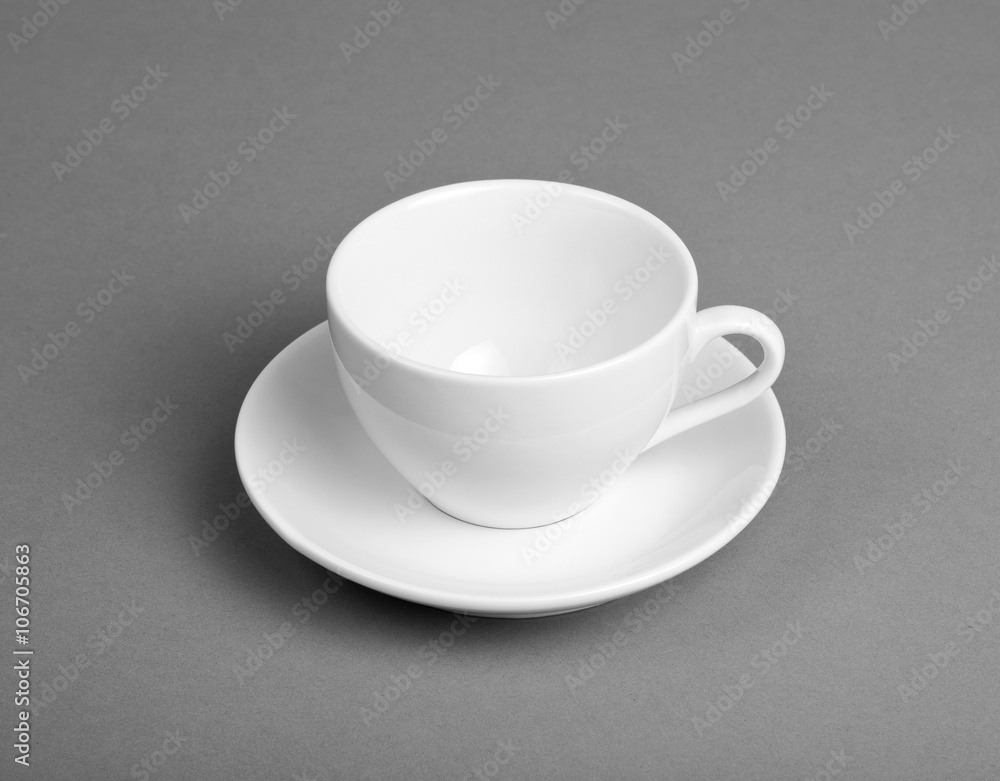 White mug and saucer on a gray background. White mug and saucer on a gray background.