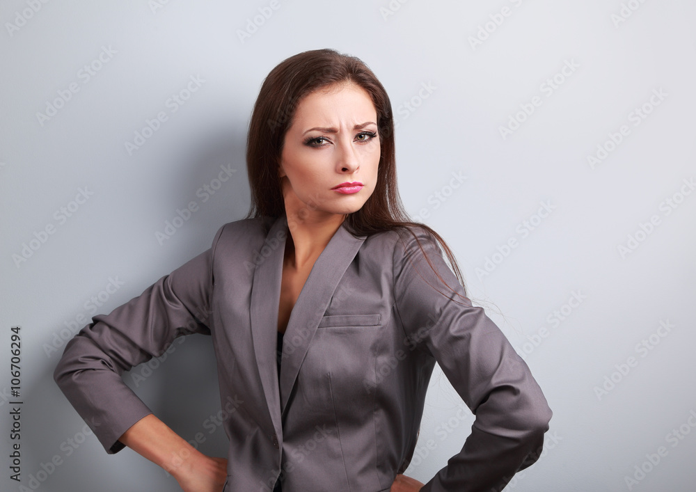 Stressed angry business woman in suit looking on blue background Stressed angry business woman in suit looking on blue background