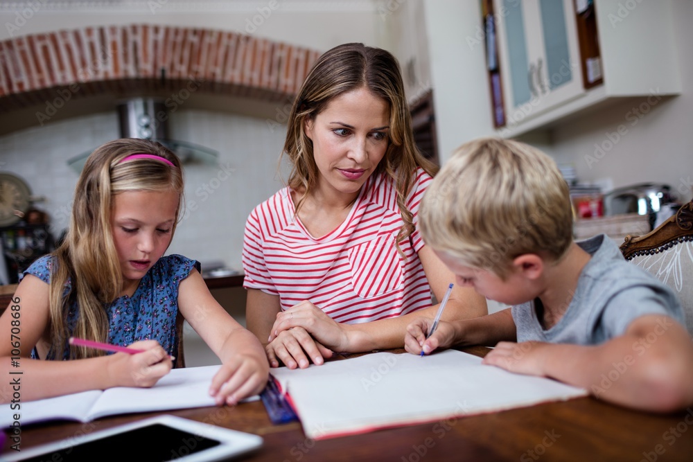Mother helping kids with their homework Mother helping kids with their homework