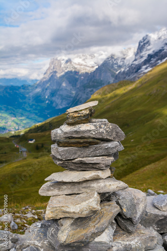 Small cairn with snow alpine mountains at background © Fominayaphoto