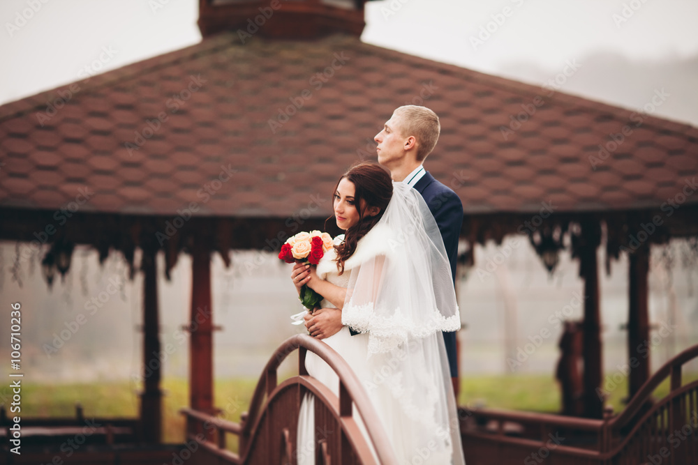 Happy wedding couple, bride and groom posing in park autumn