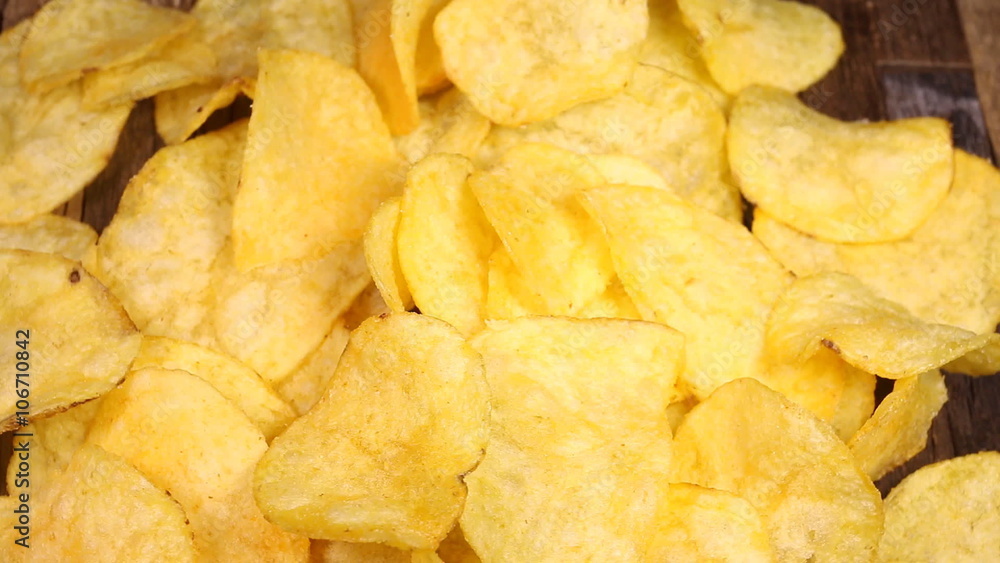 Potato chips on wooden background. Macro shot. Potato chips on wooden background. Macro shot.